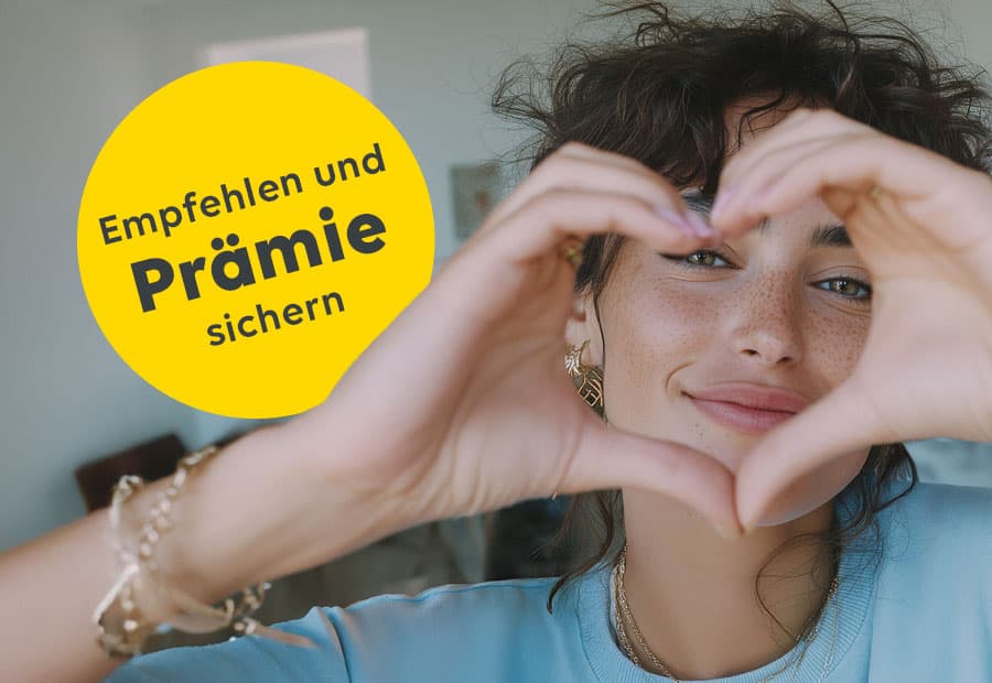 Eine Frau formt ein Herz mit ihren Fingern, durch das sie hindurchschaut.