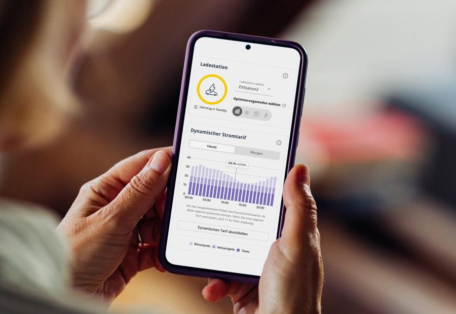 Eine Frau schaut sich auf dem Smartphone den EWE Energiemanager an