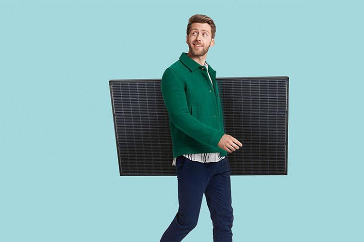 Mann trägt Solarmodul unter dem Arm