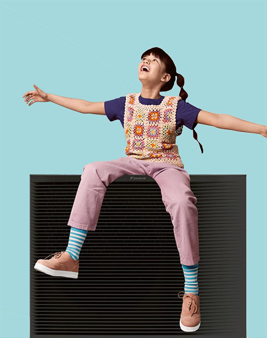 Mädchen sitzt mit ausgebreiteten Armen auf einer Wallbox