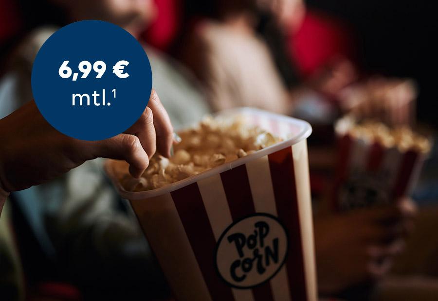 Hand, die in Popcornschachtel greift