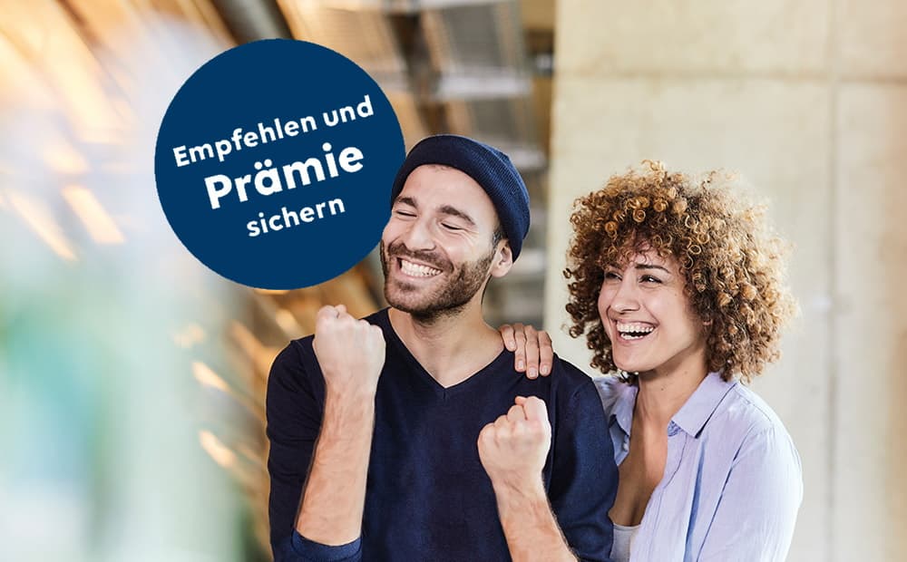 Eine Mann ballt die Faust und freut sich, eine Frau legt die Hand auf seine Schulter und lacht ebenfalls
