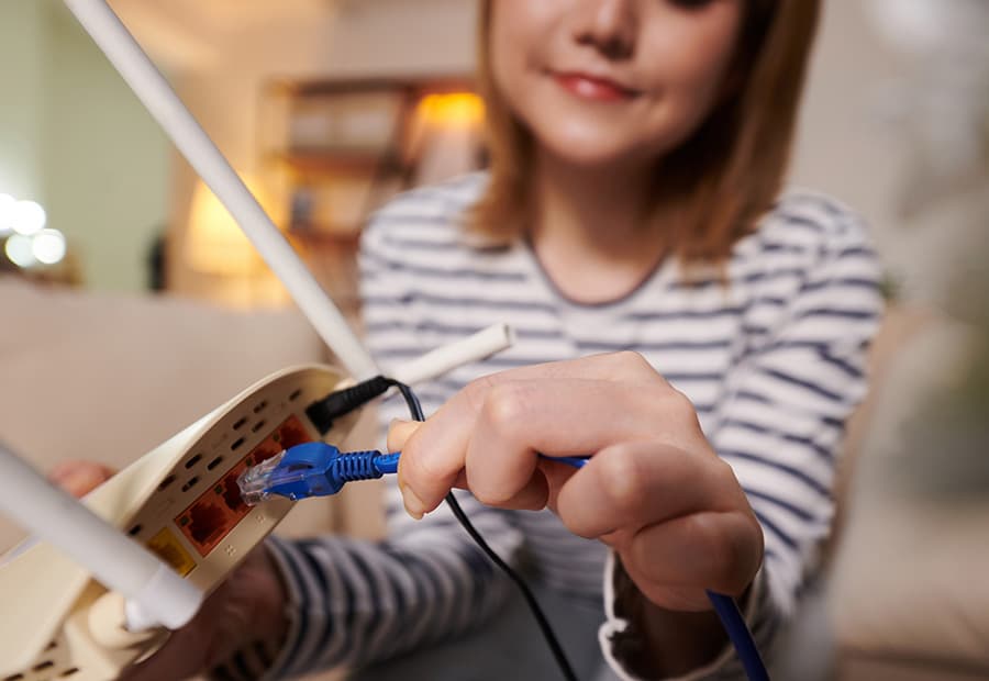 Eine Frau schließt ihren Router an.